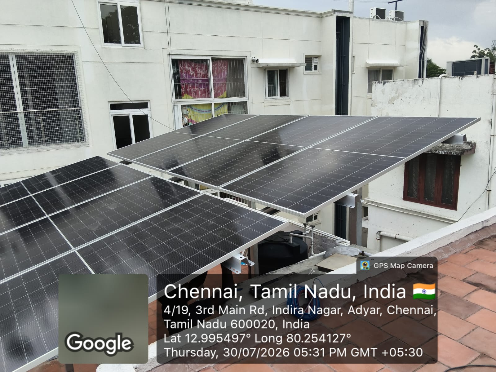 Solar installation at Adyar, Chennai — elevated terrace array over an urban rooftop.