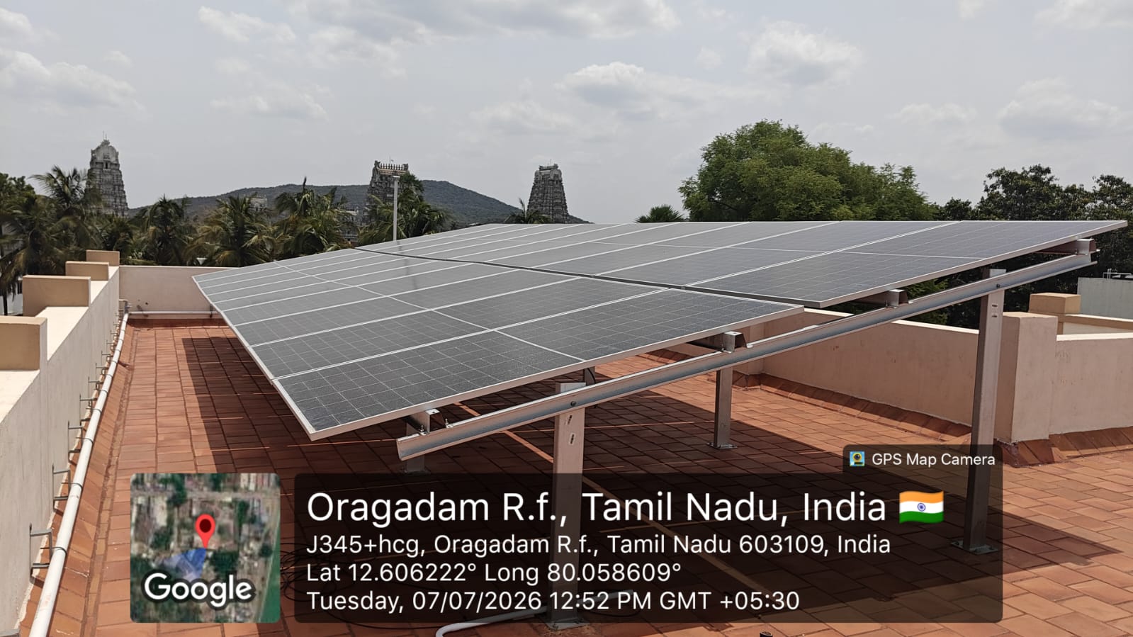 Solar panel installation at Oragadam R.f., Chengalpattu — elevated array with temple hill backdrop.
